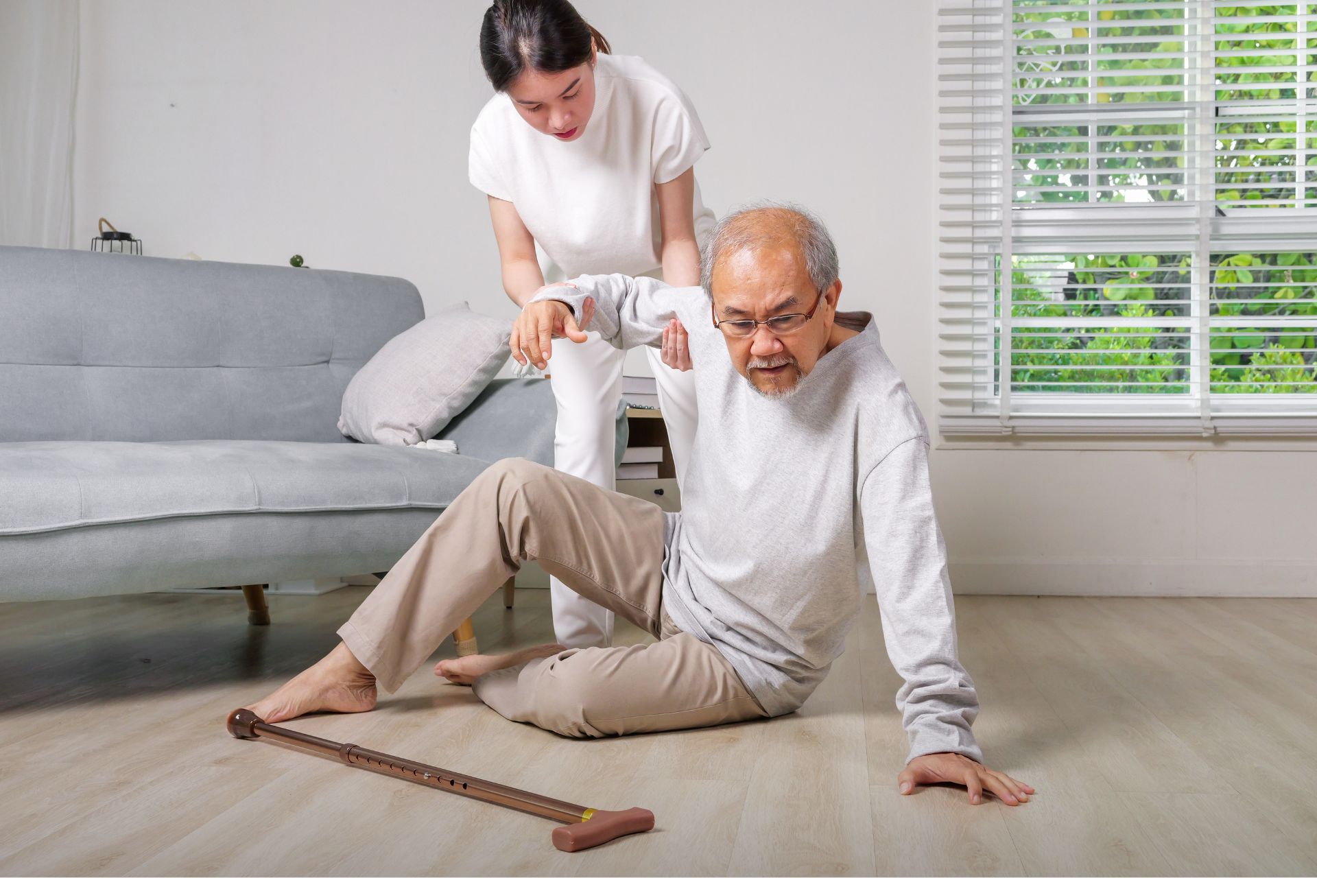 ผู้สูงอายุล้มในบ้าน ลูกสาวกำลังช่วยพยุง สะท้อนความสำคัญของการออกแบบบ้านที่ปลอดภัยสำหรับผู้สูงอายุ